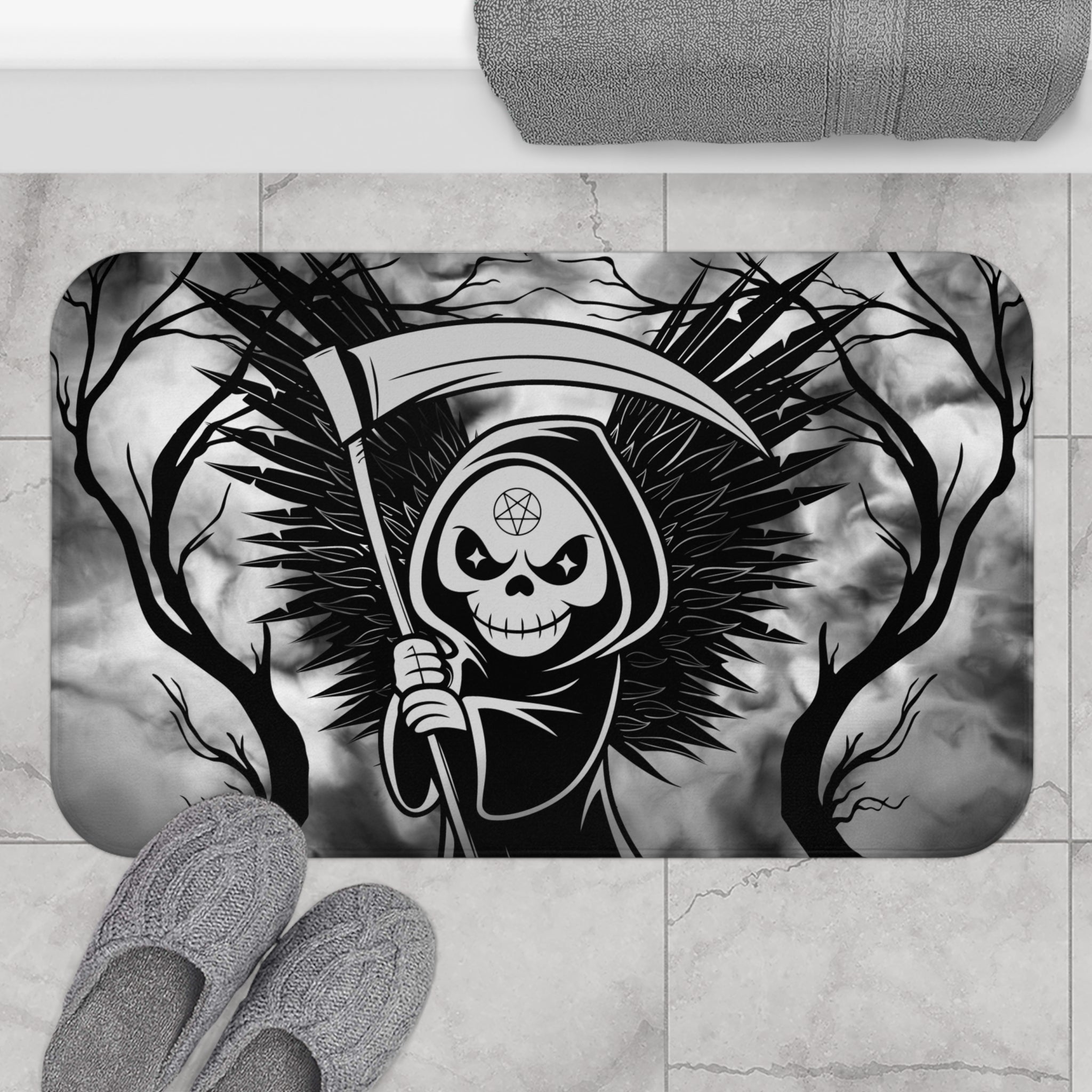 Gothic bath mat with a grim reaper holding a scythe with dark feathered wings surrounded by bare twisted branches against a swirling grey mist background in bold black and grey displayed on marble tile flooring