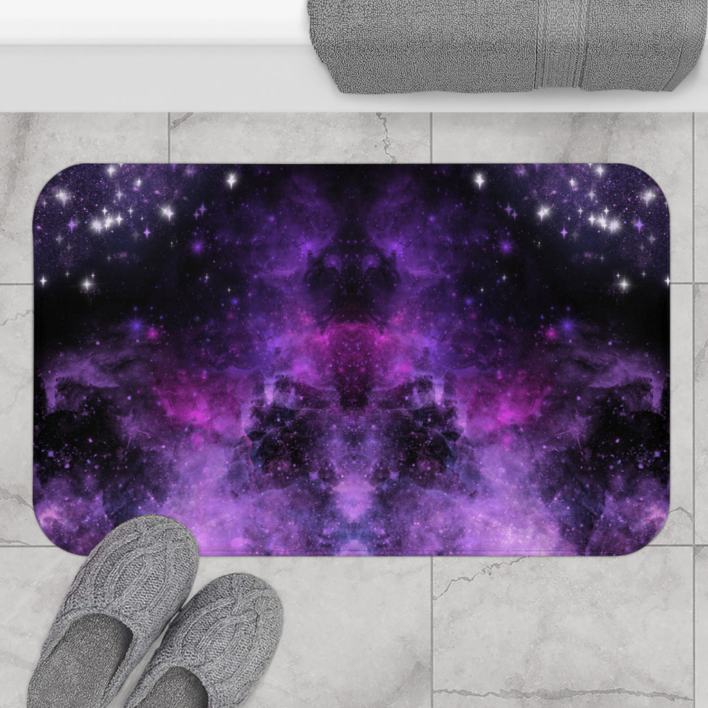 Pastel goth bath mat with a mirrored deep space nebula in swirling violet, magenta, and black with white starburst stars displayed on marble tile flooring