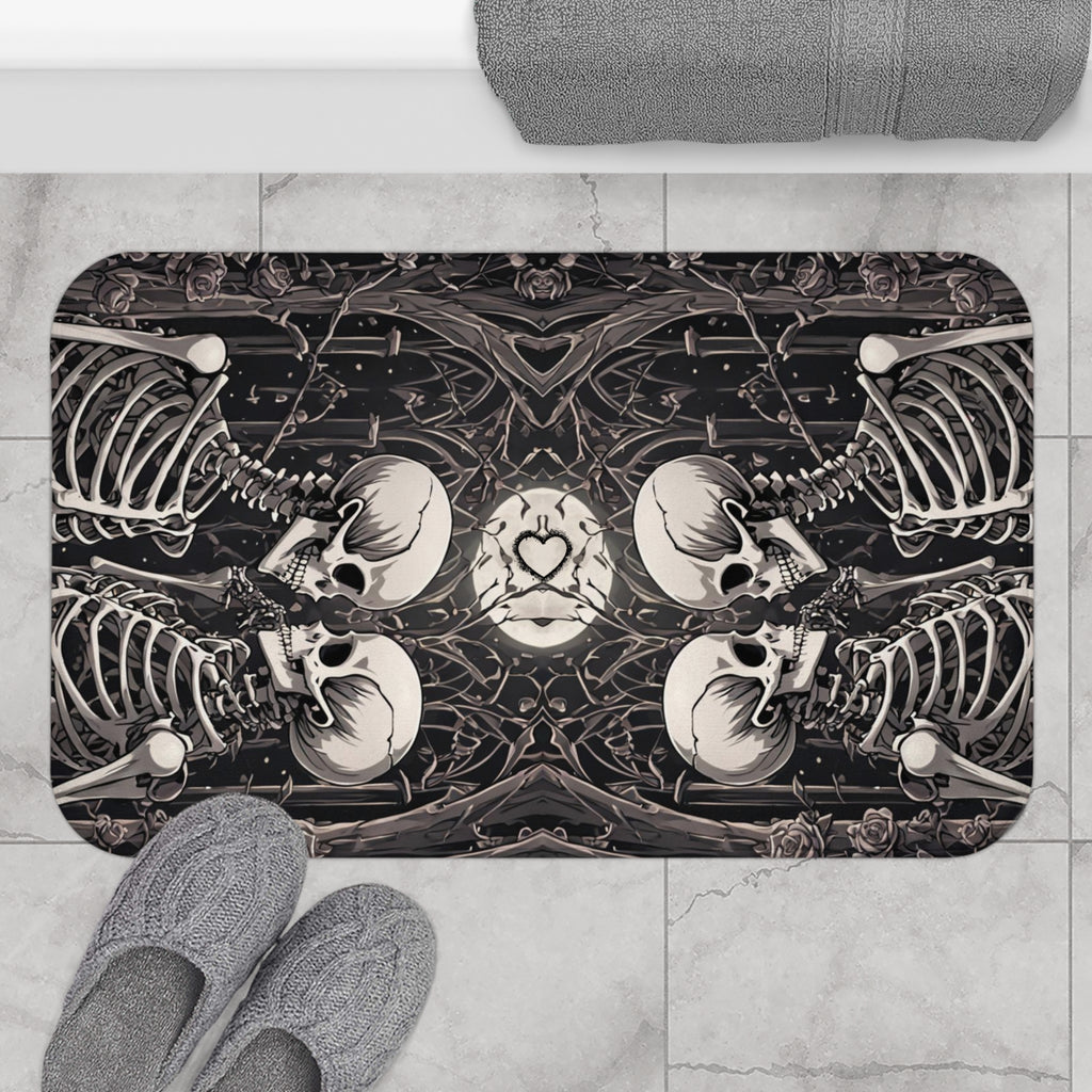 Gothic bath mat with two mirrored skeleton couples facing each other with skulls nearly touching forming a heart at center surrounded by bare branches and dark roses in deep charcoal and cream displayed on marble tile flooring