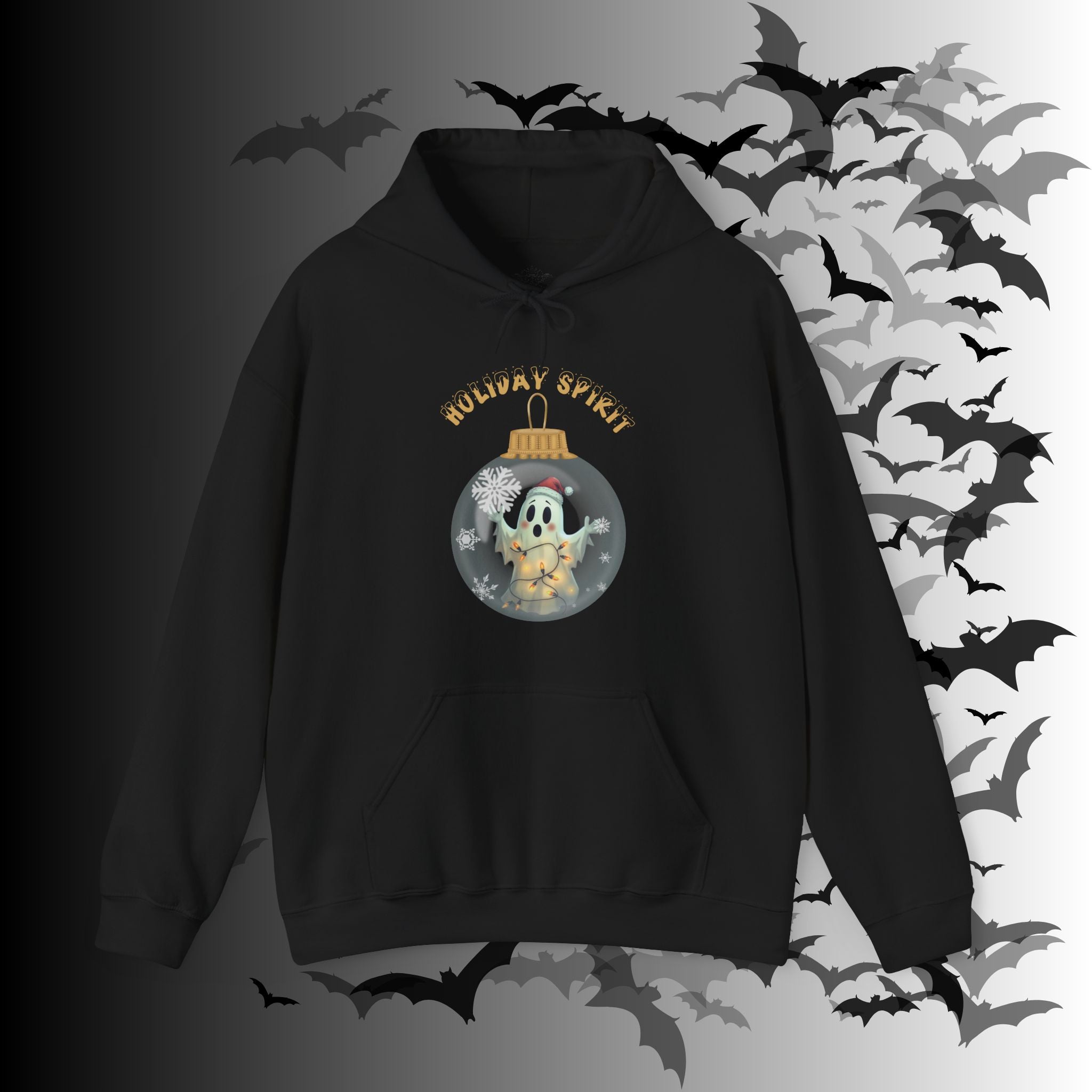 Black pullover hoodie with a kawaii ghost in a Santa hat wrapped in fairy lights inside a glass Christmas ornament with snowflakes and "Holiday Spirit" in gold gothic lettering on a bat-filled background
