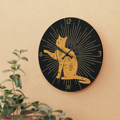 Round acrylic wall clock featuring a golden cat silhouette covered in celestial tattoo-style moon star and crystal markings on a deep black background with dramatic starburst rays radiating outward and small cat face numerals at 3 6 and 9 with black hour and minute hands