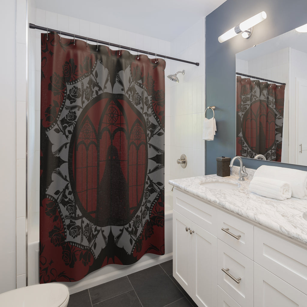 Gothic shower curtain with a cathedral window centered in an ornate mandala of bats, black roses, and grey lacework on a deep crimson to black background displayed in a white bathroom