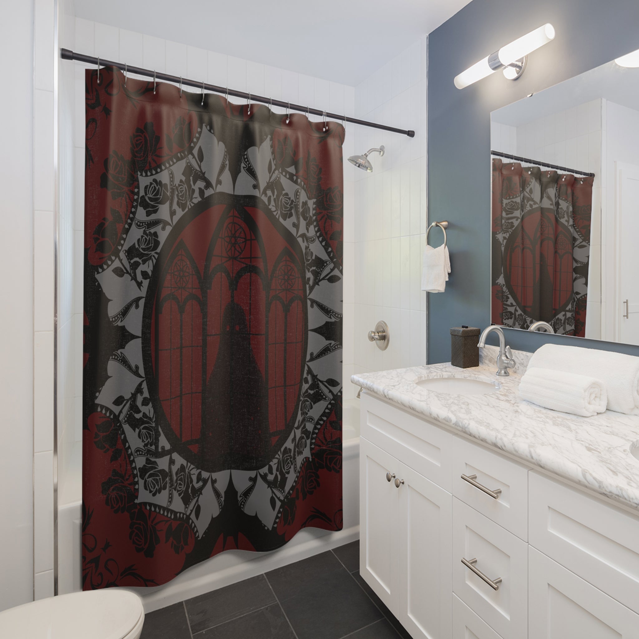 Gothic shower curtain with a cathedral window centered in an ornate mandala of bats, black roses, and grey lacework on a deep crimson to black background displayed in a white bathroom