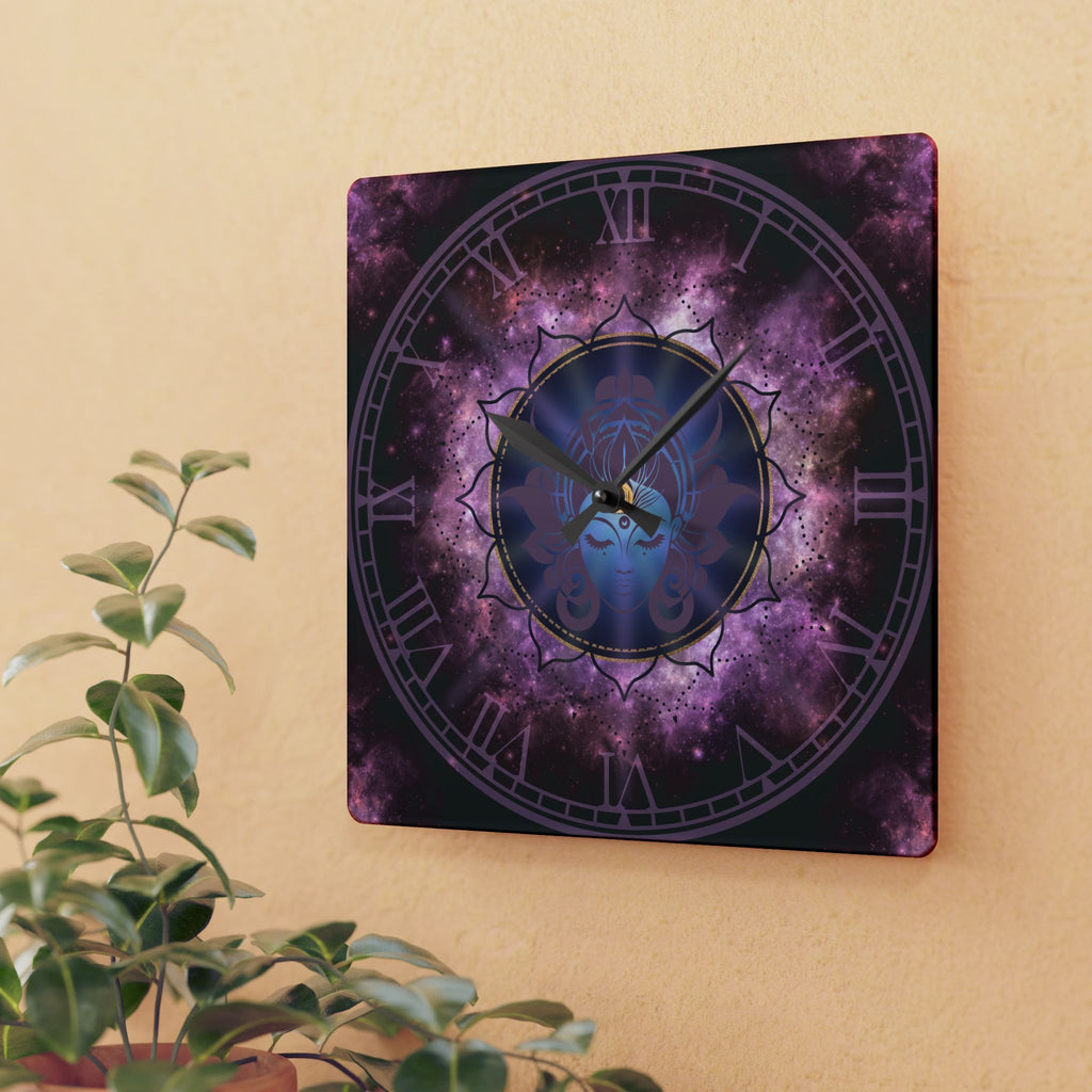 Square acrylic wall clock featuring a serene blue goddess face with third eye and lotus crown inside a gold-ringed mandala medallion surrounded by swirling purple and magenta nebula clouds with Roman numerals on a dotted outer ring and black hour and minute hands