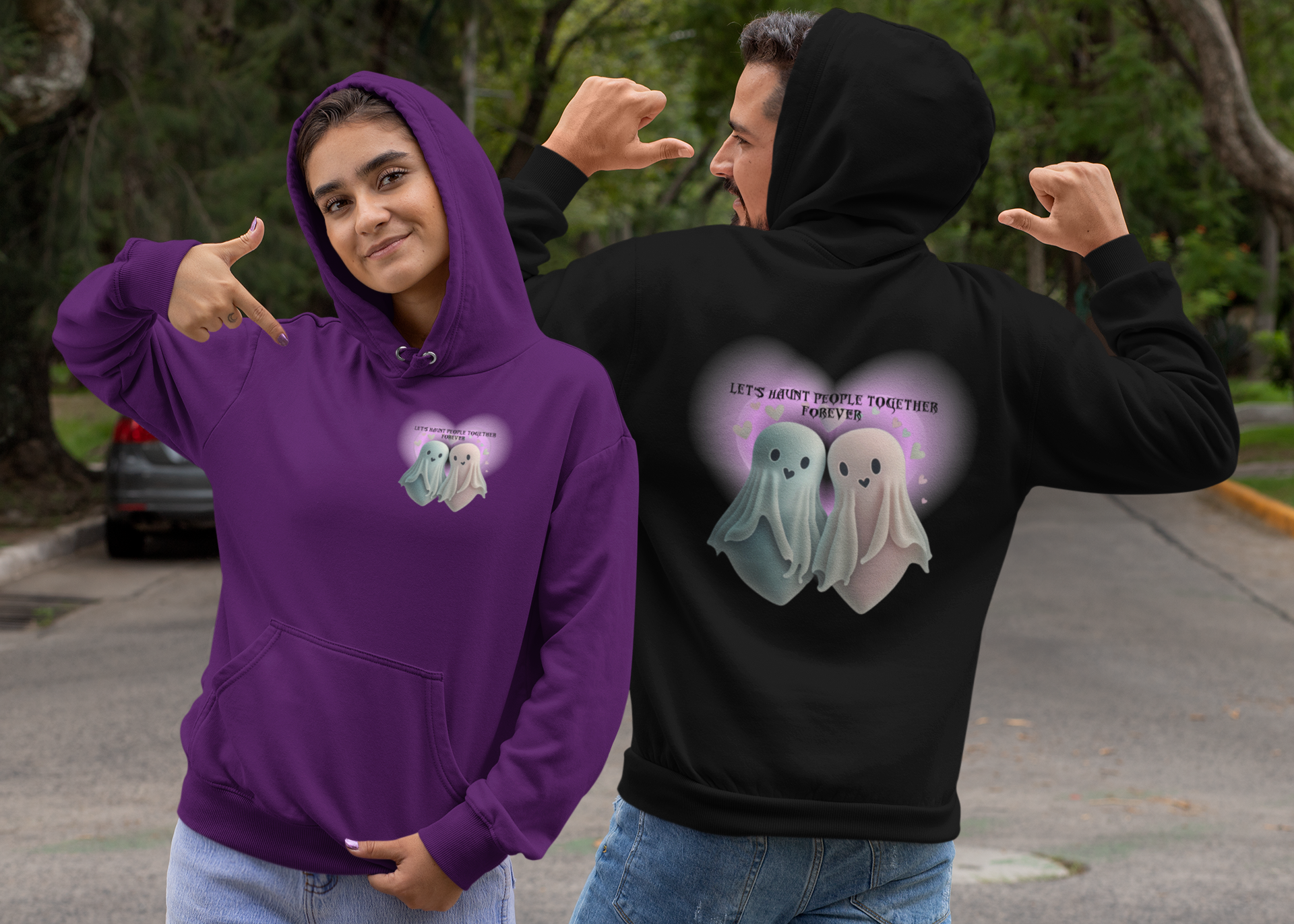 Gothic Valentine's pullover hoodie shown in purple with small ghost couple chest print and black with large back print of two kawaii ghosts inside a glowing heart and "Let's Haunt People Together Forever" text worn by a couple outdoors