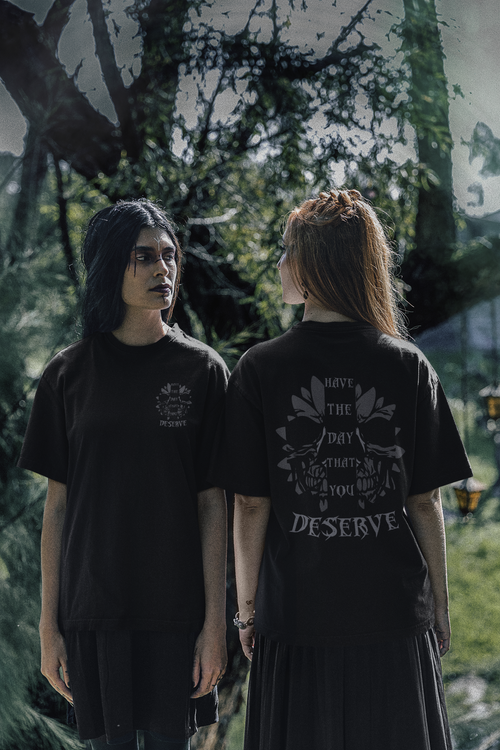 Black t-shirt front and back with tonal grey botanical skull and lotus crown graphic with "Have The Day That You Deserve" gothic lettering on the back