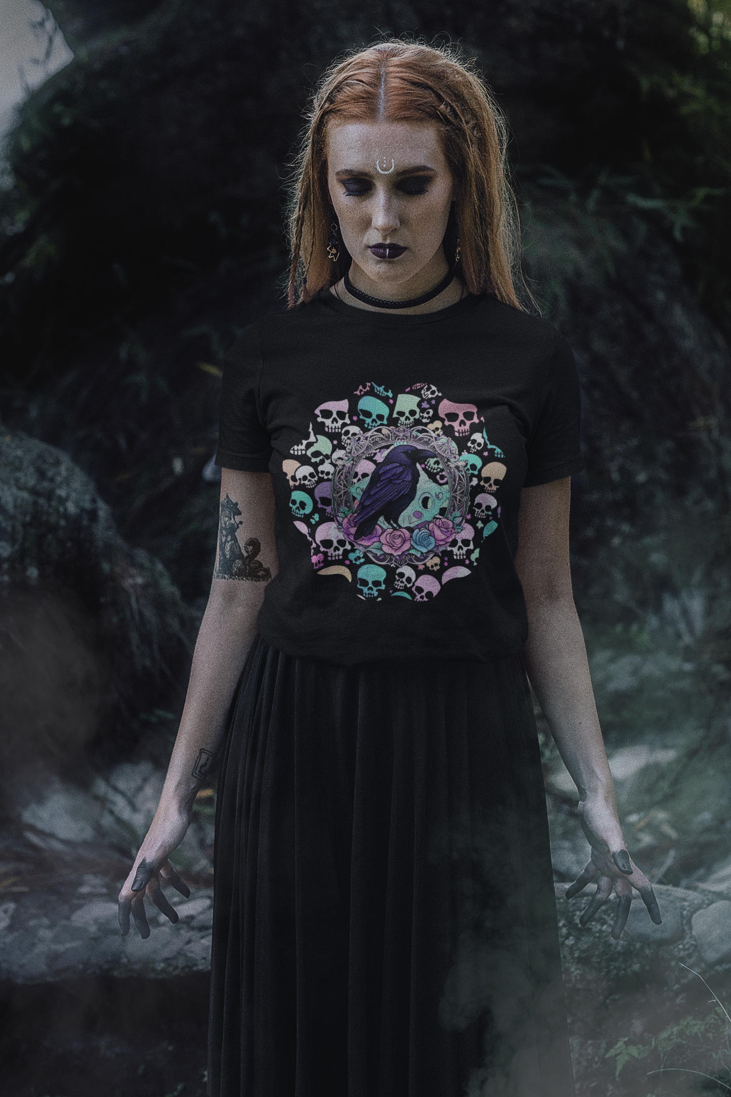 Black t-shirt with deep purple raven in ornate silver frame surrounded by a mandala ring of pastel mint, pink, lavender, and yellow skulls with pink and blue roses