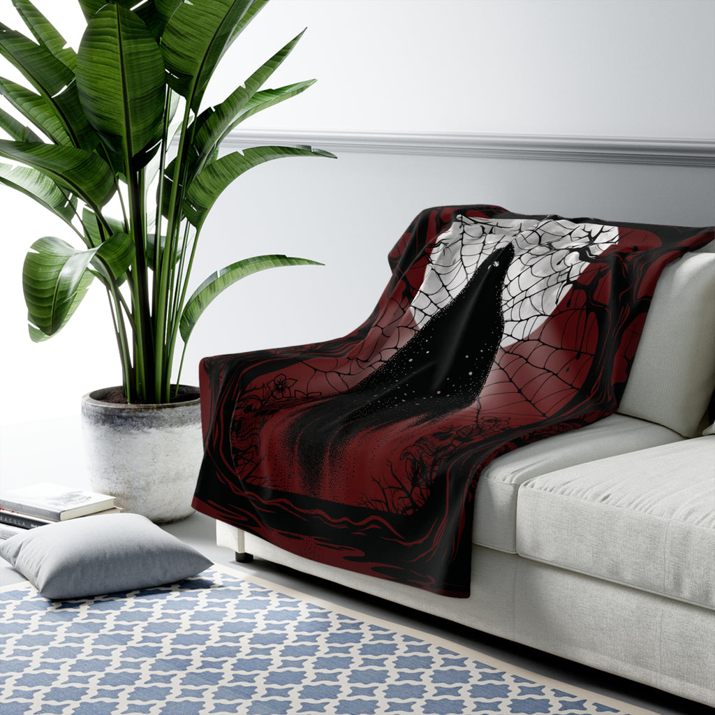 
Deep crimson and black throw blanket with ghost rising through spider webs against a blood moon with botanical shadow details draped over a sofa