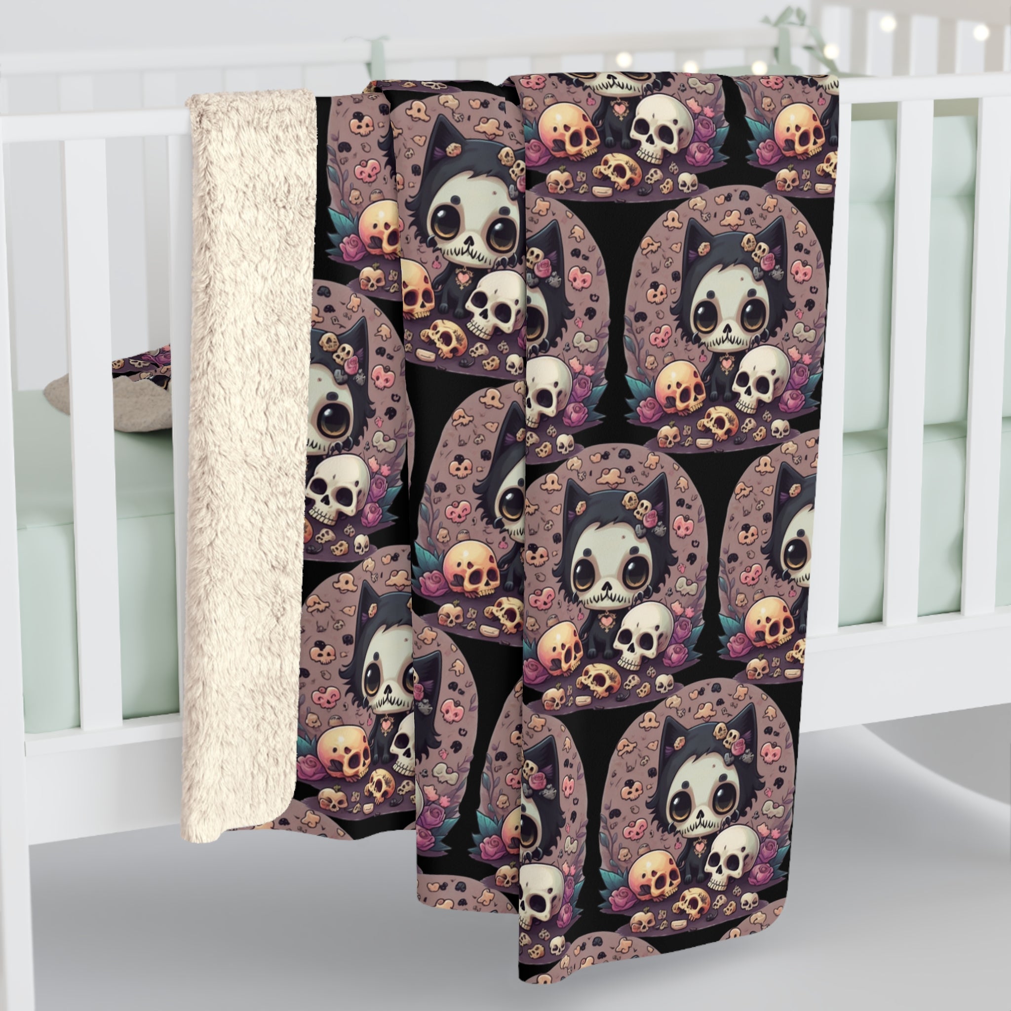 Black throw blanket with repeating pattern of kawaii skull-faced cat surrounded by skulls, pink roses, teal leaves, and scattered bones on dusty rose circular backgrounds