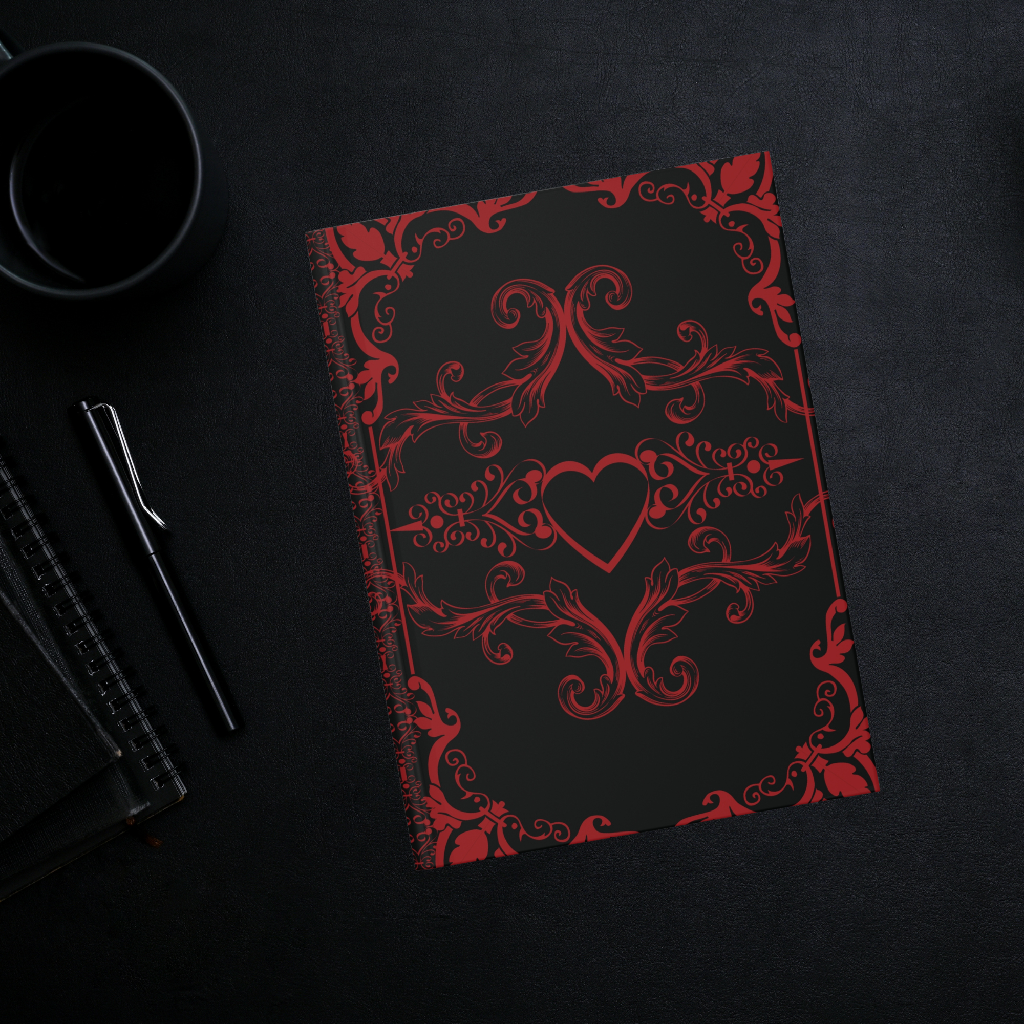 Gothic hardcover journal with crimson Victorian baroque scrollwork and centered heart design on a matte black background