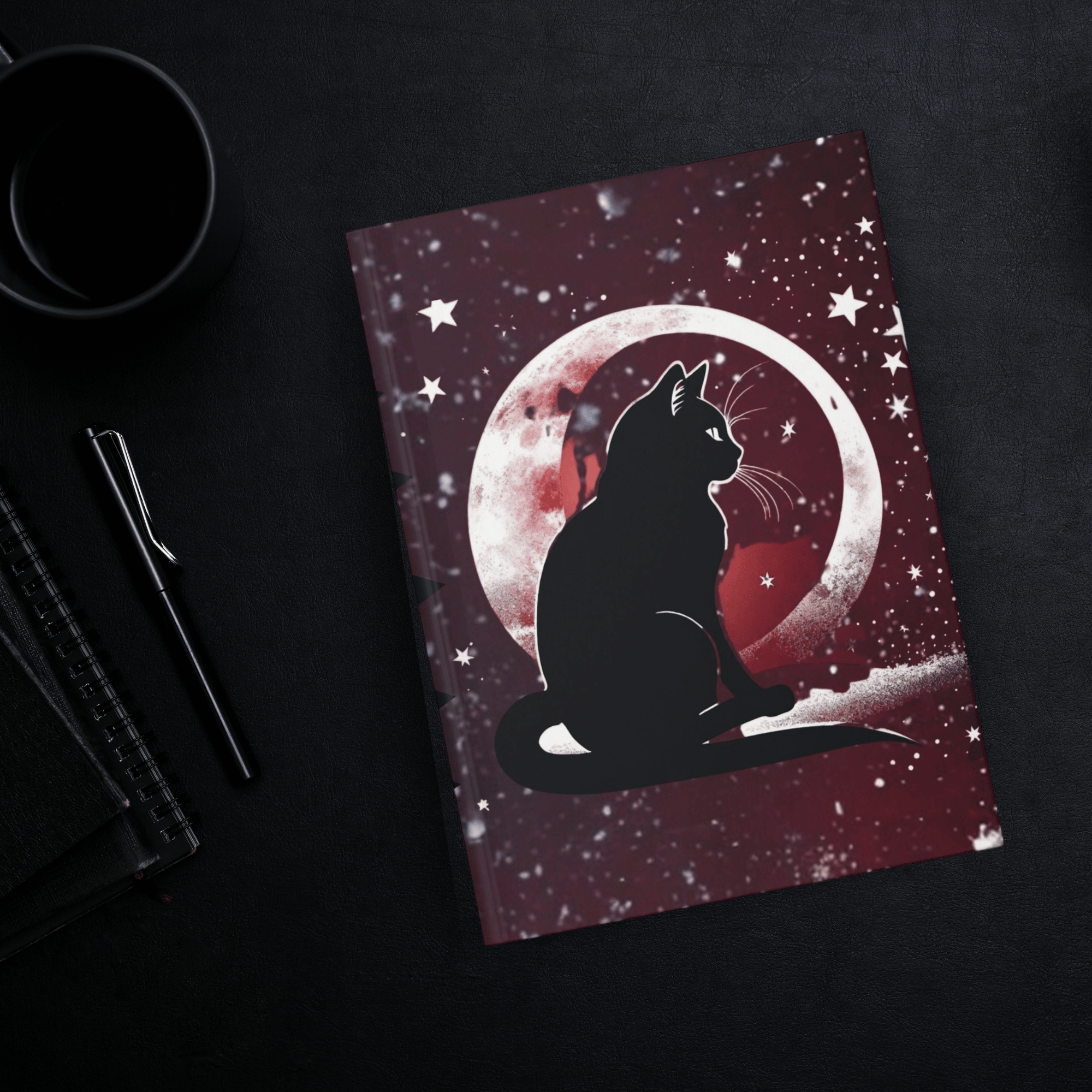 
Gothic hardcover journal open flat showing mirrored black cat silhouettes gazing at a glowing full moon against a deep crimson and indigo starfield with white stars