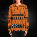 Person wearing an orange Halloween-themed sweater with black patterns on a dark background.