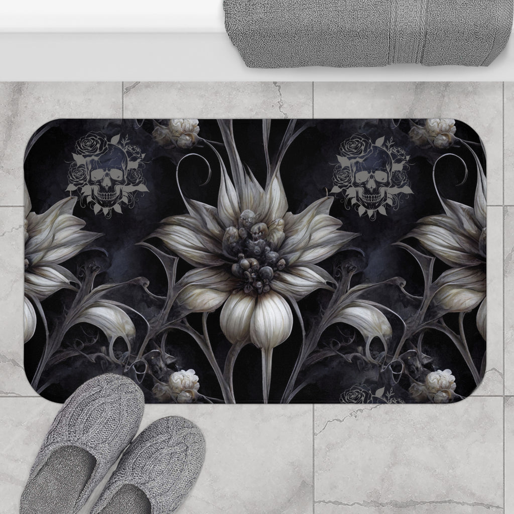 Gothic bath mat with oversized ivory and ash botanical blooms with skeletal dark vines and rose-crowned skull medallions on a deep smoky black background displayed on marble tile flooring