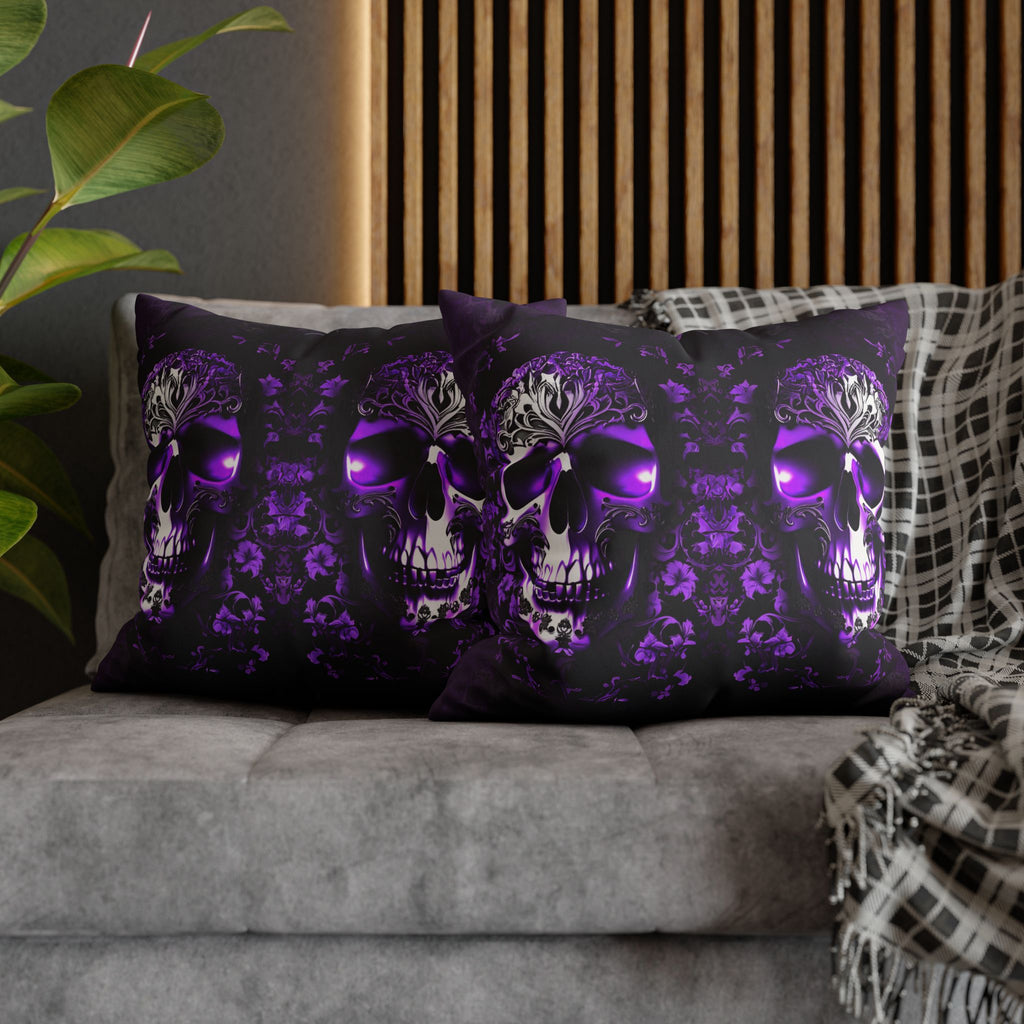 Two square throw pillows on a grey sofa featuring a large ornate skull with glowing violet eyes and baroque filigree crown detailing against a deep purple damask floral pattern on black background