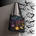 Black polyester tote bag with rainbow geometric crystals, purple and amber crescent moons, golden orbs, and four-pointed star bursts on a deep black background