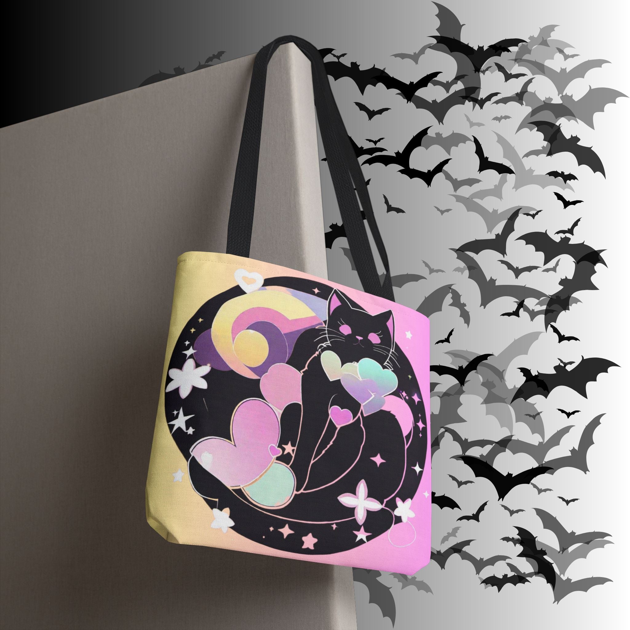 Pink and yellow gradient polyester tote bag with black cat silhouette inside dark moon circle surrounded by pastel heart balloons, rainbow arc, and star accents