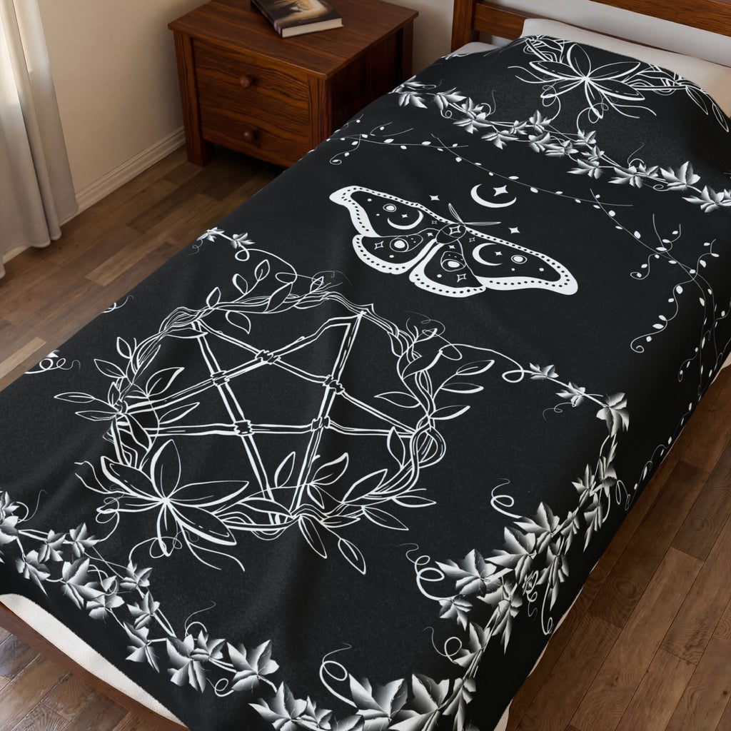 Black throw blanket with white linework luna moth in upper corner with pentagram and trailing botanical vine details