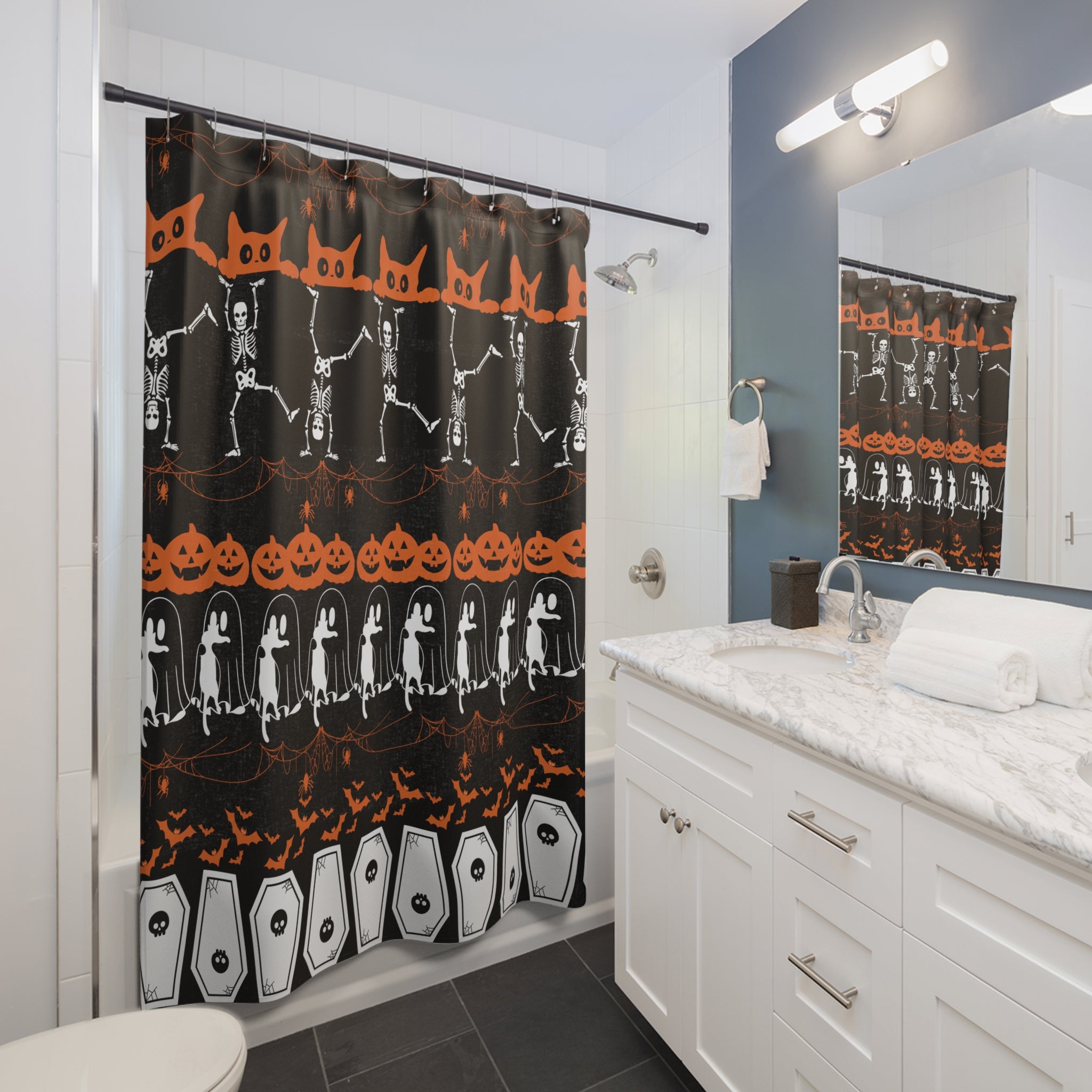 Black shower curtain with horizontal bands of orange and white Halloween characters including jack-o-lanterns, dancing skeletons, drifting ghosts, black cats, swooping bats, and coffins, hanging in a white bathroom