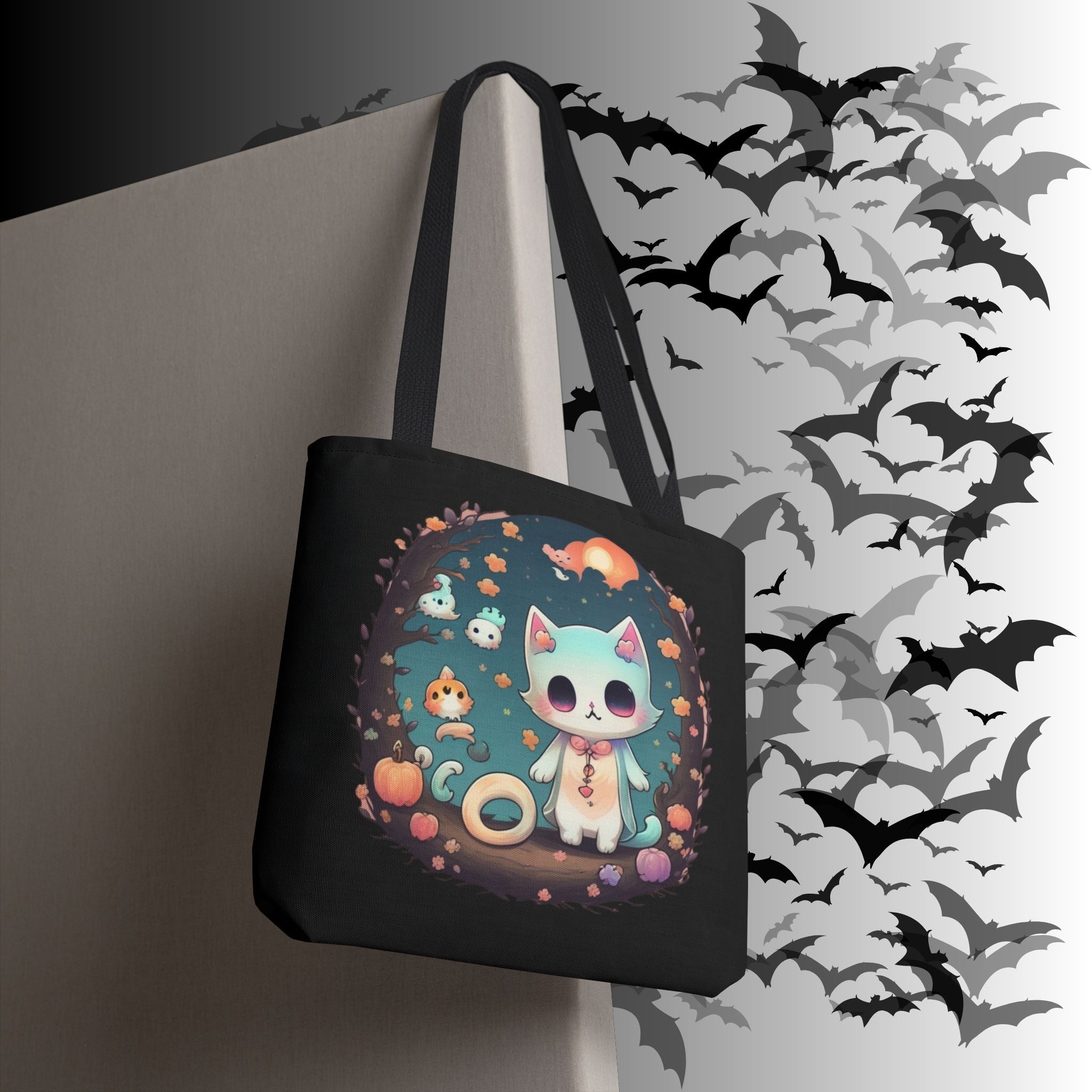 Black polyester tote bag with circular moonlit forest scene featuring a pastel teal kawaii cat with ghost creatures, pumpkin, and autumn floral border