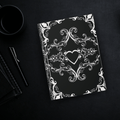 Gothic hardcover journal with white Victorian baroque scrollwork and hearts on a deep matte black background