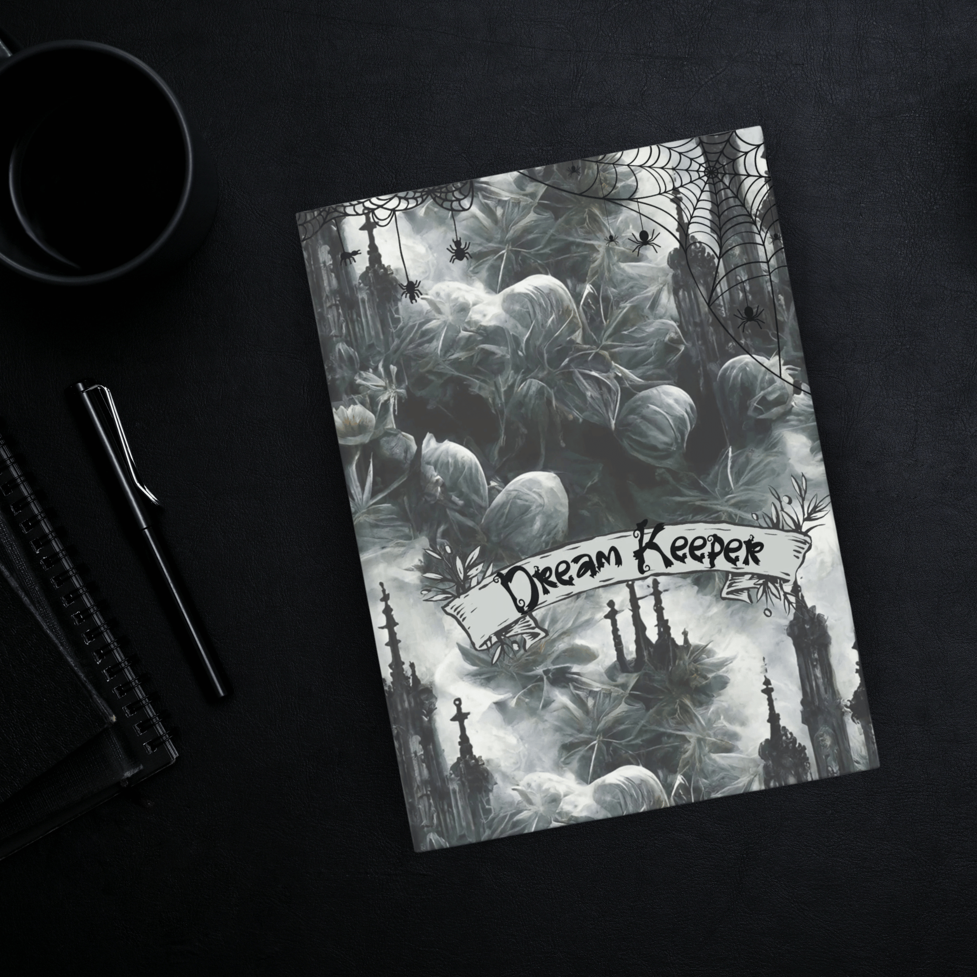 Gothic hardcover journal with "Dream Keeper" ribbon banner over ghostly pale florals, cobweb-draped Gothic spires, and black spiders on a misty silver-grey background