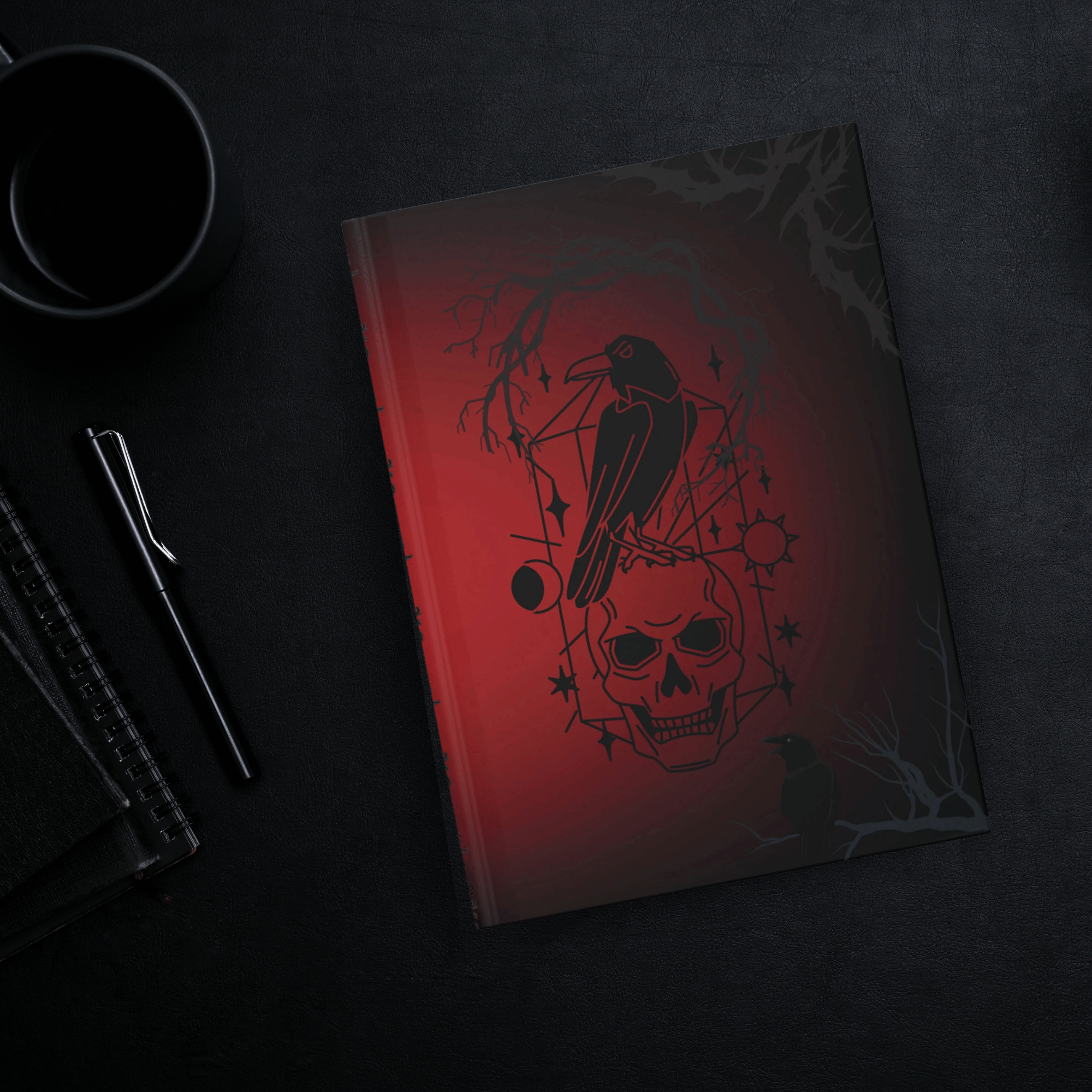 Gothic hardcover journal with black raven perched on a skull surrounded by celestial geometric diagram, bare branches, and starburst accents on a deep crimson to black gradient background