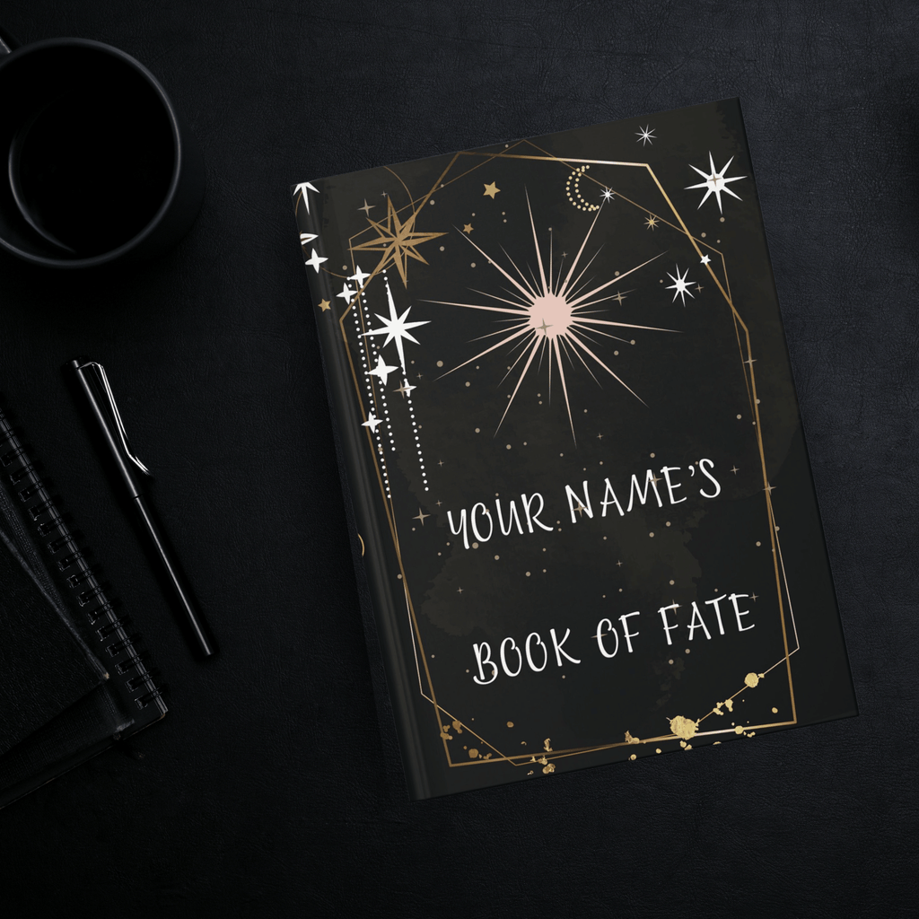 
Personalized gothic hardcover journal open flat showing celestial tarot card design with gold geometric arch, starbursts, crescent moons, and "Your Name's Book of Fate" text on deep black background