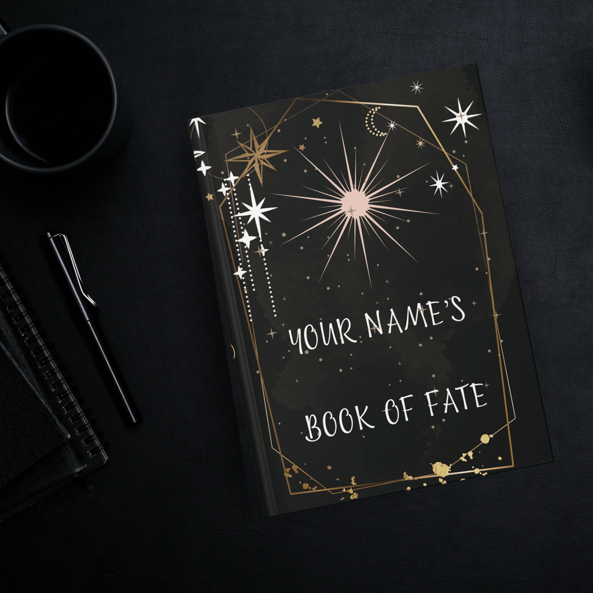 
Personalized gothic hardcover journal open flat showing celestial tarot card design with gold geometric arch, starbursts, crescent moons, and "Your Name's Book of Fate" text on deep black background